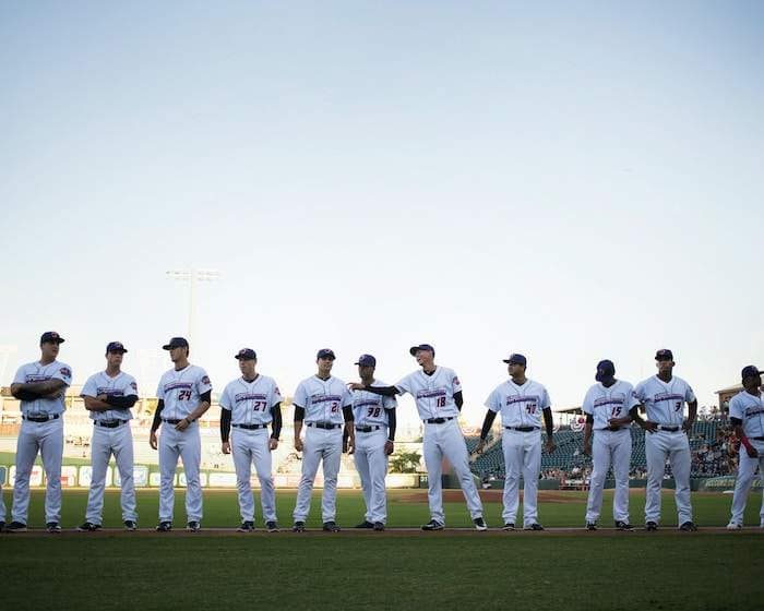 baseball team standing on green field