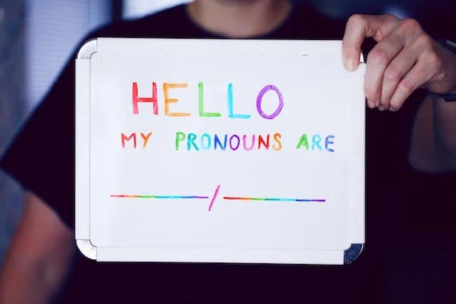 hello my pronouns are written on white board in rainbow colors