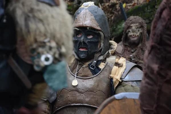 orc wearing armor with other orcs around him