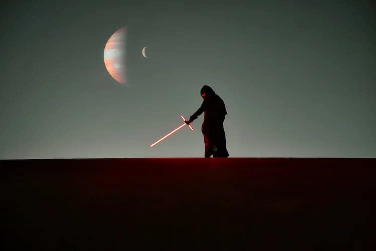 star wars character with lightsaber and jupiter and moon behind