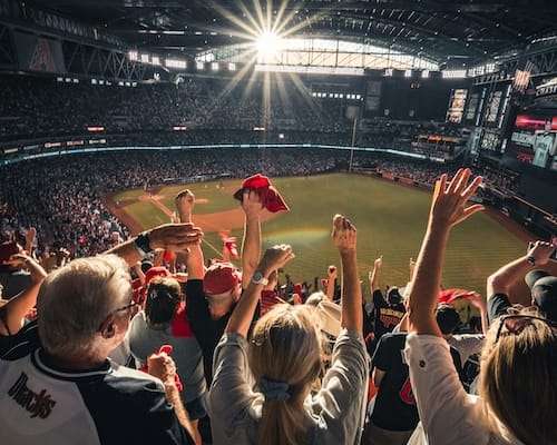 friends watching a baseball game in the stadium with their hands raised